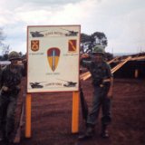 "Uknown Cannon King (Left) & Tom Watkins (Right) Pose By ABtry 6/27th Arty Sign - April 1968"